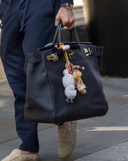 Labubu dolls hang from a designer bag