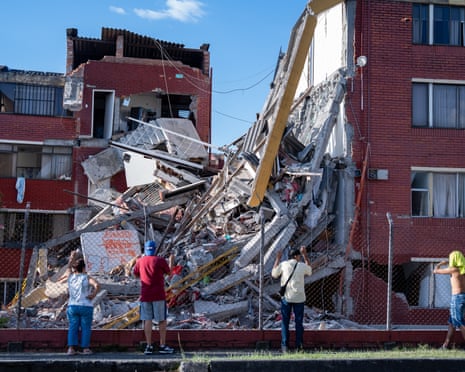 People look at damaged homes in Pereira
