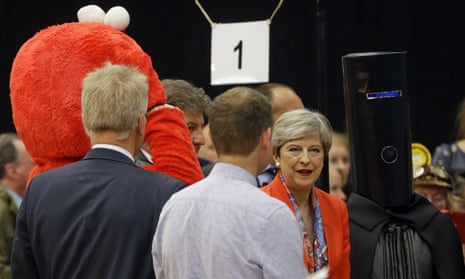 Britain’s Prime Minister Theresa May, center, stands next to candidate ‘Lord Buckethead’ in Maidenhead.