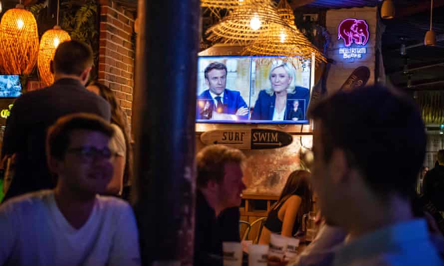 Het debat wordt op het scherm getoond in een bar in Parijs