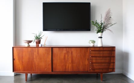 A vintage sideboard below a wall-mounted flatscreen TV