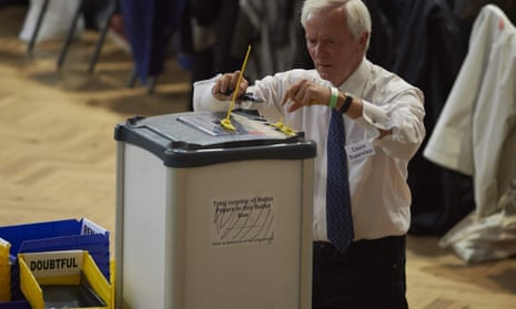 A counting supervisor opens a ballot box  at The Royal Horticultural Halls in central London