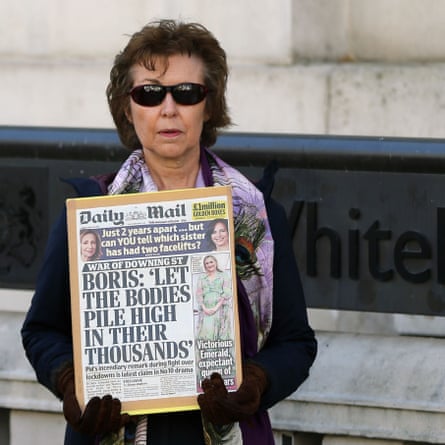 A protester holds cover page of the British newspaper Daily Mail outside the Cabinet Office, April 2021.