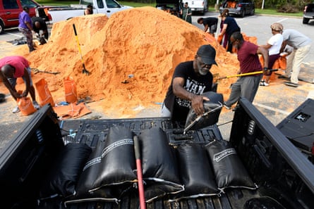 people putting sandbags into a car
