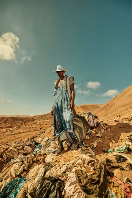 Model dressed in denim and a cowboy hat poses in the desert