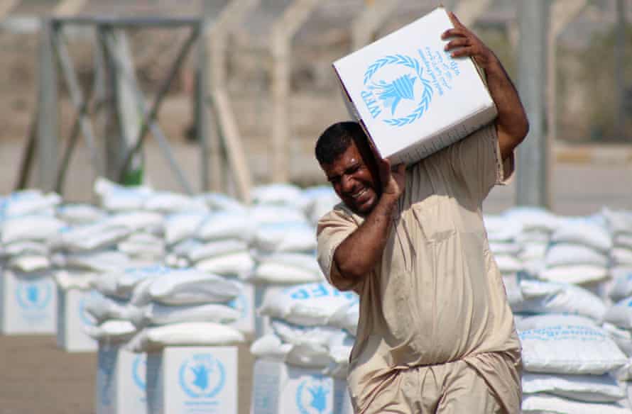 An Iraqi collect boxes of food donated by the World Food Programme.