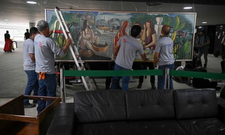 Workers replaced a smashed mirror where a vandalized painting hung in Brasília after Bolsonaro supporters stormed congress.