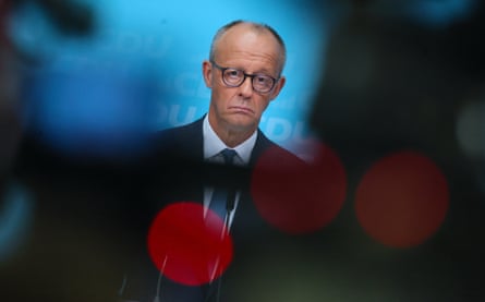 Friedrich Merz addresses a news conference. He looks unhappy and downcast.