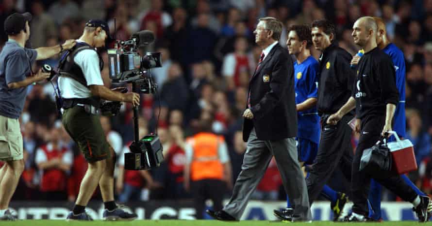 Manchester United manager Alex Ferguson triumphantly struts across the Highbury pitch after the final whistle.