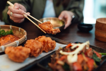 Someone eating fried chicken with chopsticks