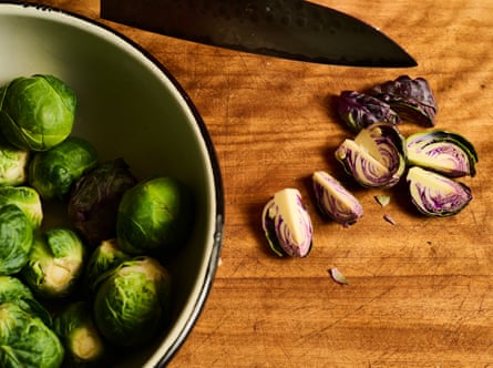 Green and purple sprouts on a chopping board and in a bowl.