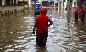 People walk through flood waters after a widespread flood in Sylhet district