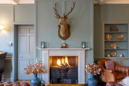 The head of a deer mounted on a wall above a fire in a pub lounge in the Highlands