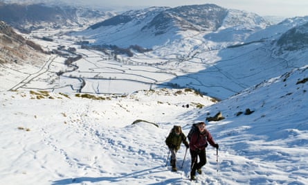 Two hikers looking down to Great Langdale in winter conditions.