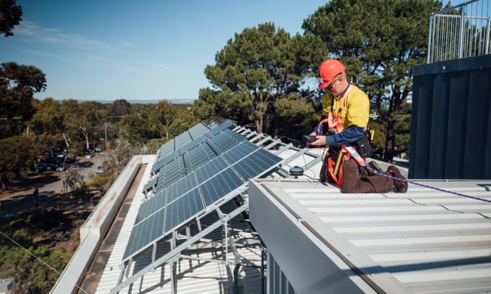 Man on roof connecting solar panels