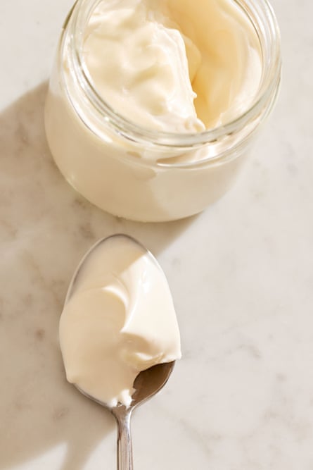 A jar and spoon holding whipped cream.