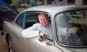 Andy Palmer, the CEO of Aston Martin, posing with a 1963 Aston Martin DB5 outside the London Stock Exchange.
