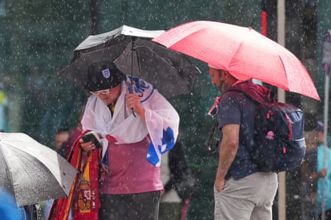Fans carry umbrellas