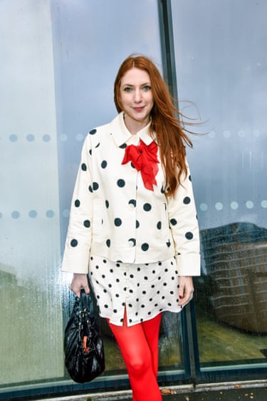 A person wearing a black-and-white polka dot outfit and red tights