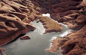 A houseboat on the shore in shallow water in a canyon at Lake Powell near Page, Arizona, US.