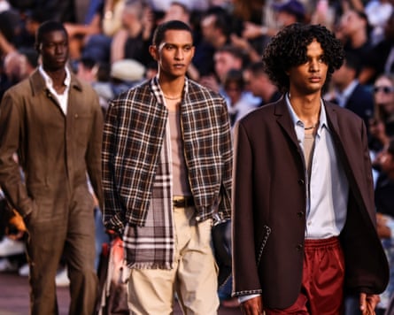 Three models walk down the catwalk during the show
