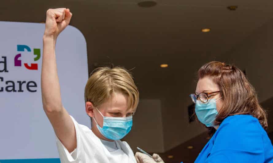 Charles Muro, 13, celebrates being inoculated by caregiver  Karen Pagliaro successful  Hartford, Connecticut.
