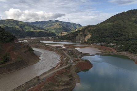 A pool of water and the riverbank surrounded by hills.