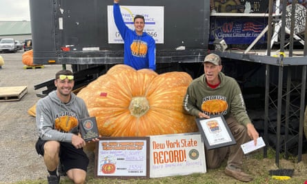 Scott Andros, a la derecha, posa con una calabaza que batió récords en Clarence, Nueva York, el 1 de octubre de 2022.