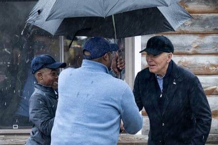 Joe Biden greets supporters under an umbrella