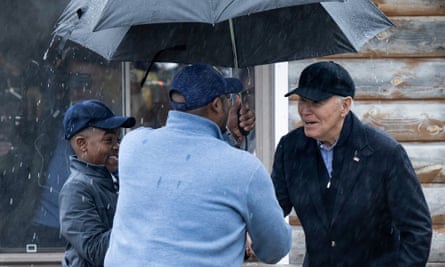 Joe Biden tries to avoid getting soaked during a visit to Saginaw, Michigan, in March this year.
