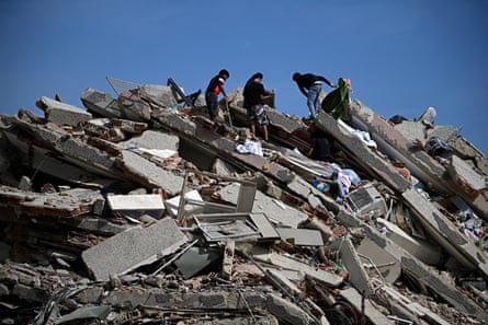 People search for survivors amid the collapsed floors of a multi-storey building.