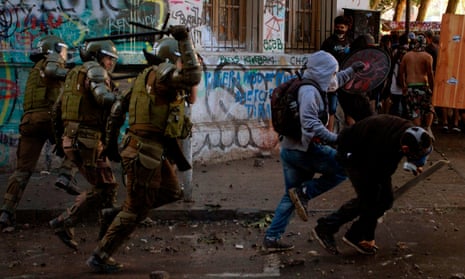 Riot police chases demonstrators during a protest against the government in Santiago on November 19, 2019.