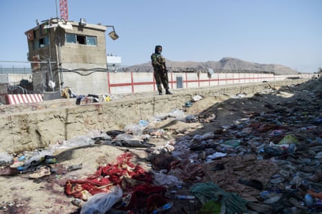 A Taliban fighter stands guard at the site of the suicide bombing at Kabul airport