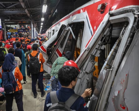Rescuers work to evacuate trapped passengers from the wreckage after the collision