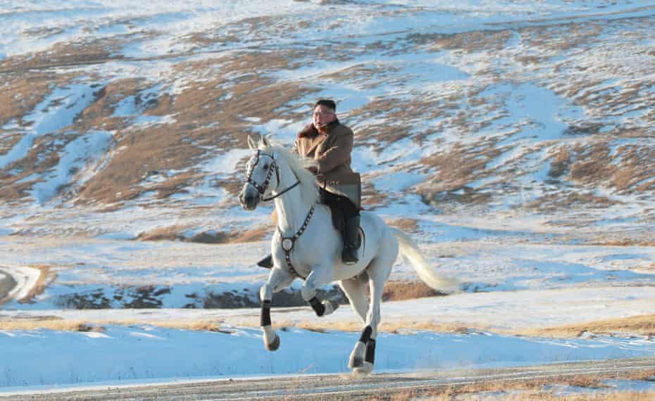Kim rides a white horse amongst the first snow at Mount Paektu