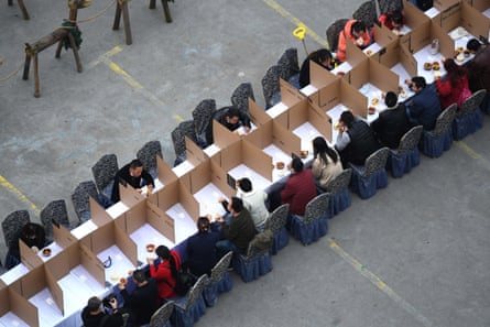 Tourists separated from each other by cardboard have a lunch outside a restaurant at a scenic spots amid the coronavirus outbreak on March 16, 2020 in Chongqing, China.