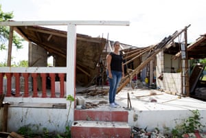 Norma Judith Coln stands in front of her damaged home after hurricane Mara.