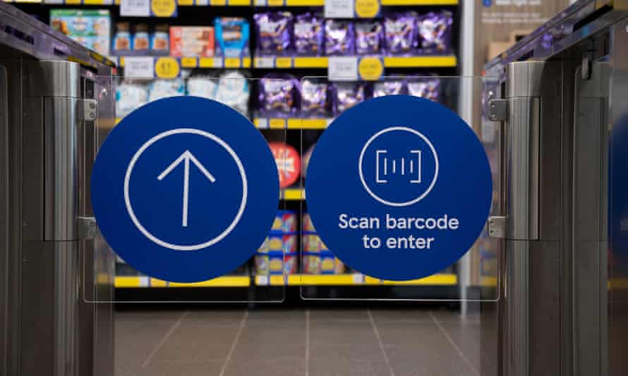 The transparent barriers to Tesco's smart supermarket, with large blue round stickers indicating where shoppers scan their barcode to enter