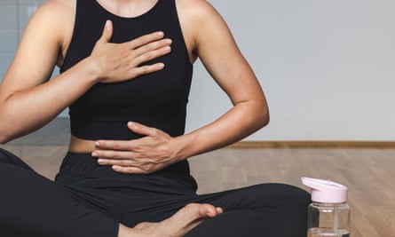 Woman doing breathing exercise sitting in lotus position.