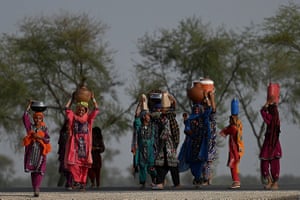 Women carry drinking water to their homes on the outskirts of Jacobabad, Pakistan