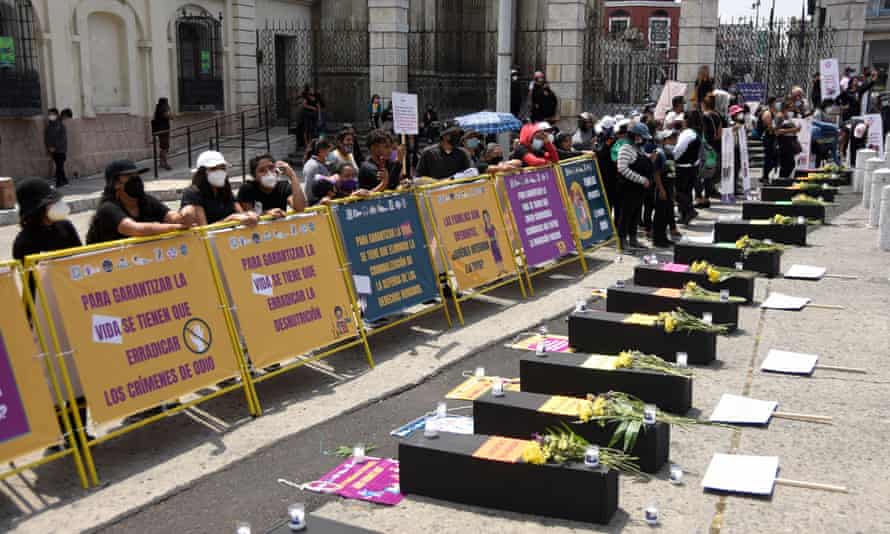 People protest next to mock coffins during a ceremony taking place outside the Culture Palace in Guatemala City on Wednesday.