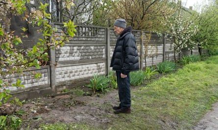 Oleksandr Kalinichenko looking at the destroyed house.