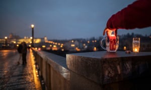 A man lights a candle in a beer glass on the bridge in the Old Town district amid the COVID-19 pandemic on January 03, 2021 in Prague, Czech Republic.