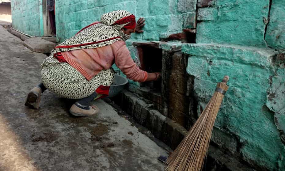 A manual scavenger cleaning a dry toilet in TK1 village near Agra, Uttar Pradesh