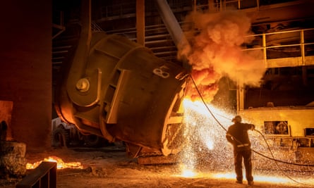 Sparks fly from a huge flask being emptied out at a steelworks