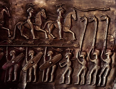 Figures, some on horse and some with shields in metal relief alongside three players