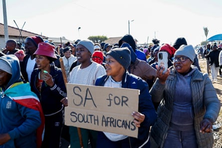 Protesters carry traditional weapons and banners at an anti-immigration rally in Gauteng province.