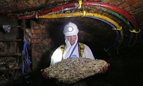 A ‘flusher’ holds a fatberg in a London sewer.