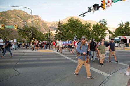 Opposing protest groups march on opposite sides of the street in Provo.