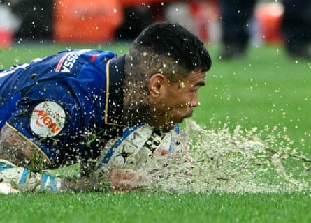 Italy wing Monty Ioane falls to the deck and sends water flying as the conditions worsen in Rome